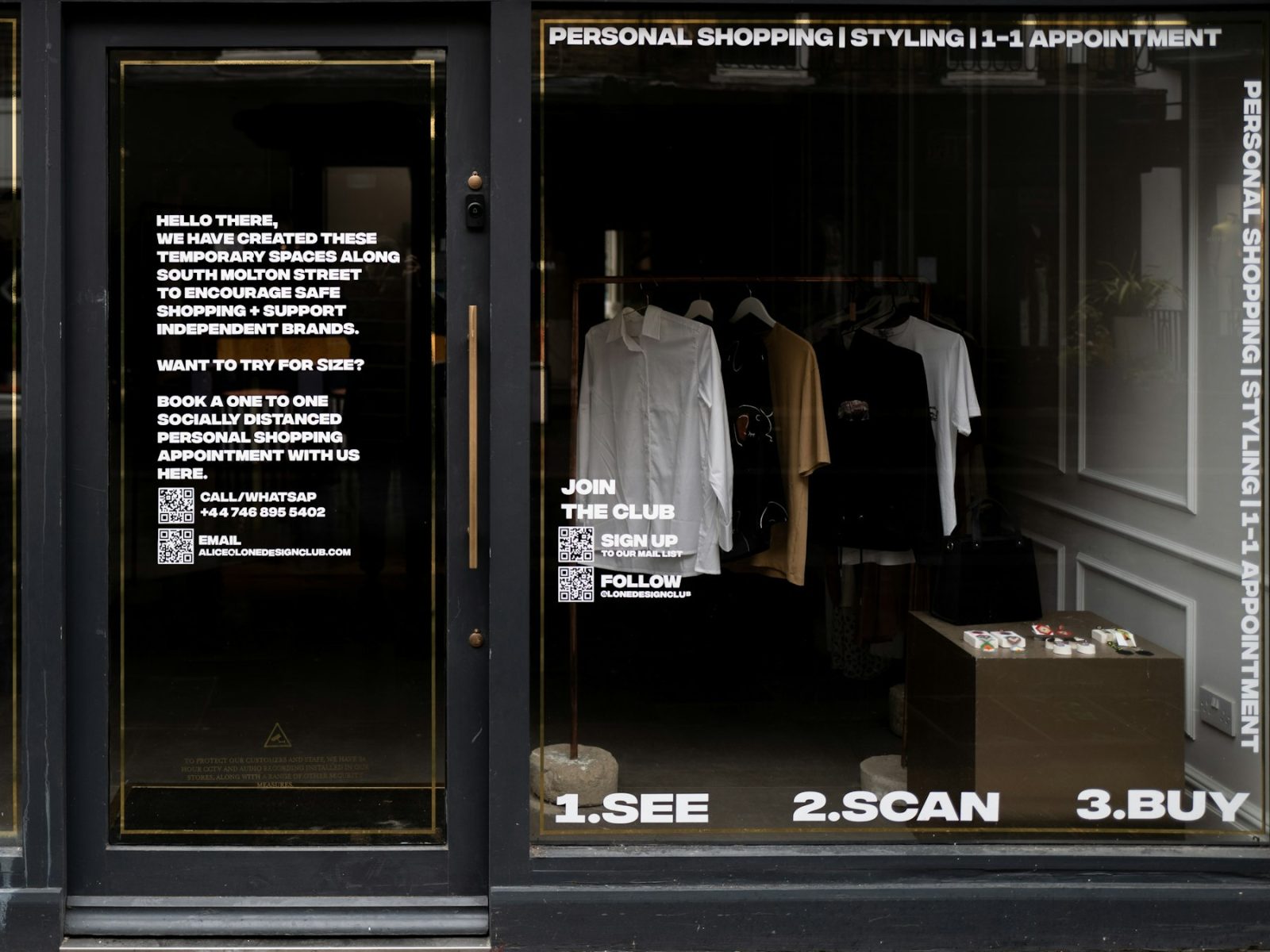 Ladenfront mit weißer Fensterbeschriftung: Hinweistext, QR-Codes und drei Schritte am unteren Rand