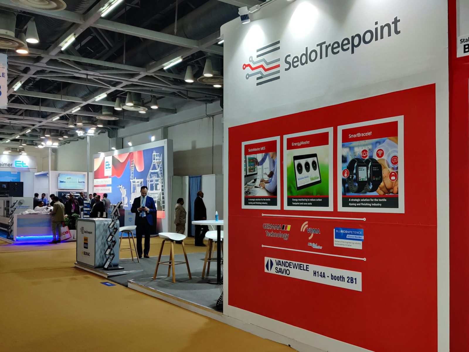 Messestand mit roter, bespannter Rückwand und Bildflächen