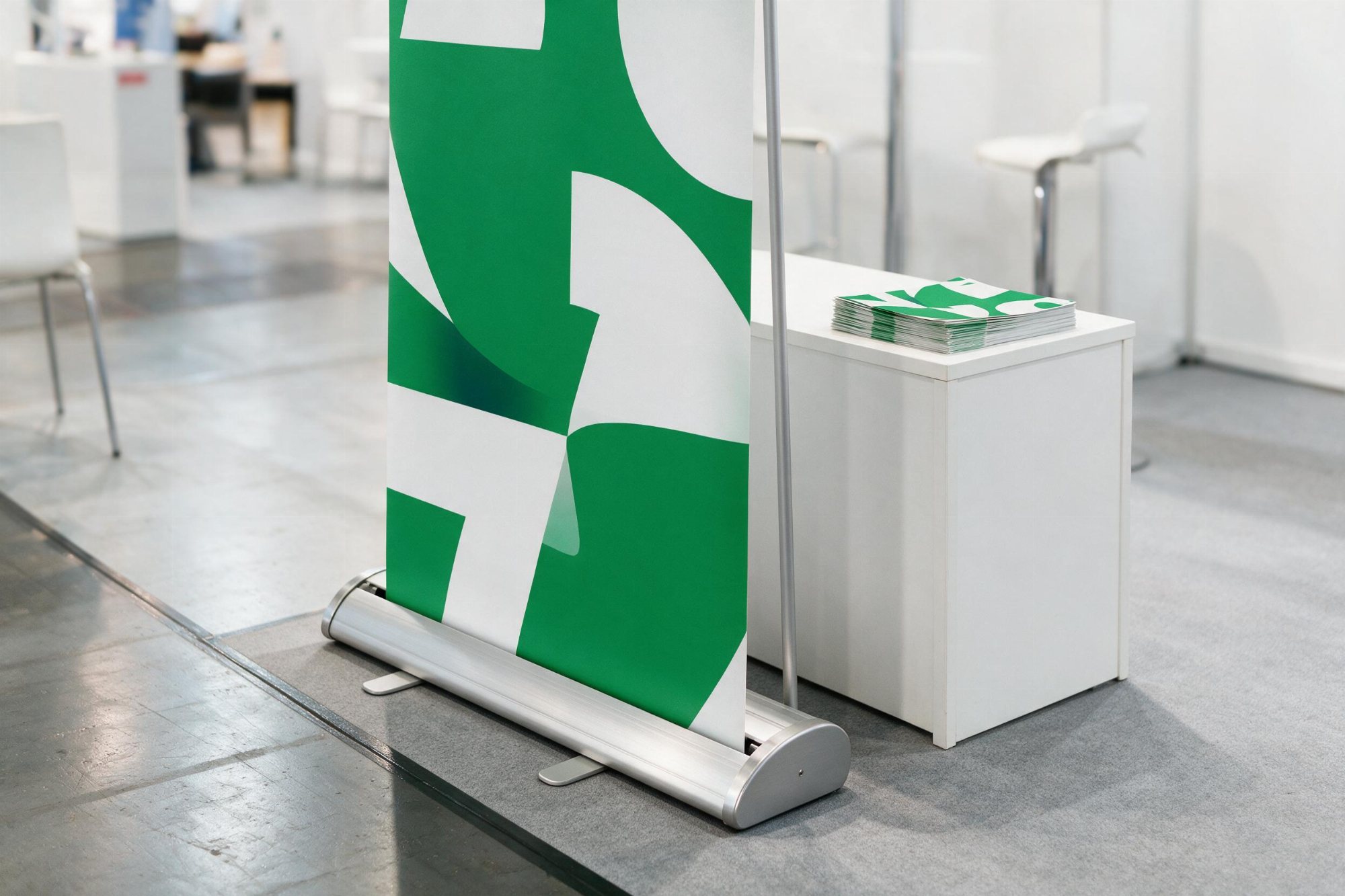 Messestand mit Roll-Up und Flyerstapel auf der Theke