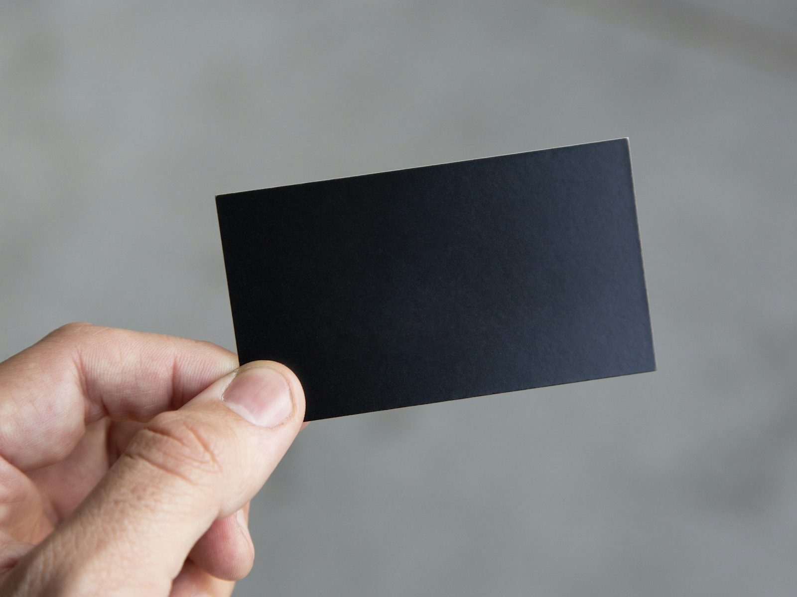 Hand hält eine schwarze Visitenkarte